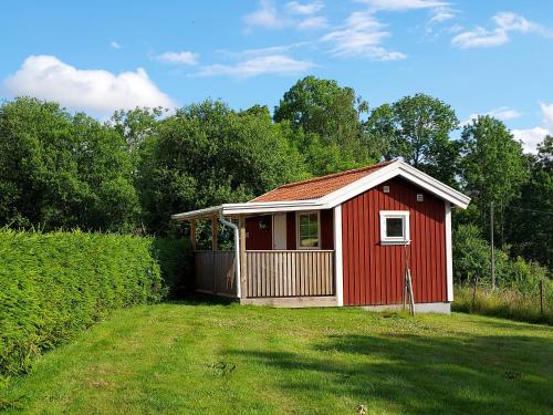 a red shed in a field with a yard at Älgbergets Bed & Breakfast in Ucklum