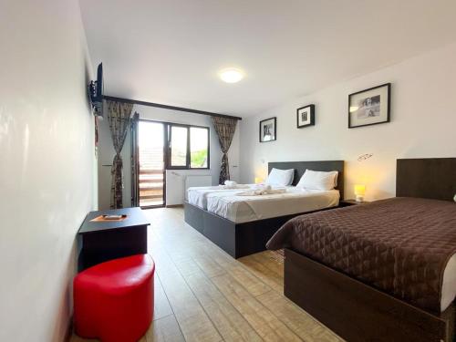 a hotel room with two beds and a red stool at Casa Mura in 2 Mai