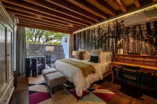 a bedroom with a bed and a desk and a window at Casa Cien Hilos in San Miguel de Allende