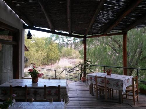 un patio con 2 mesas y sillas en una terraza en Rocas Amarillas en Valle Grande