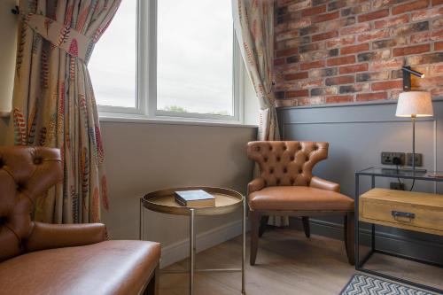 a room with a chair and a table and a window at Sandburn Hall in York