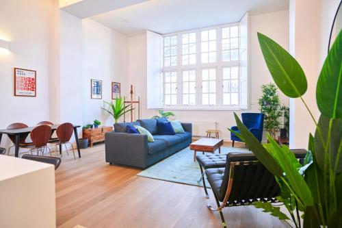 a living room with a blue couch and chairs at GuestReady - Sophisticated Home in Shoreditch in London