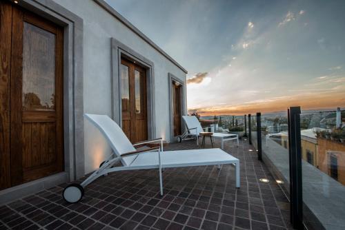 a balcony with a table and chairs on a building at Casa Cien Hilos in San Miguel de Allende