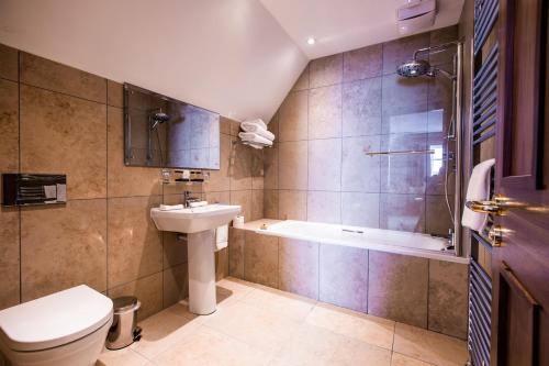 a bathroom with a sink and a tub and a toilet at Ballygally Castle in Larne