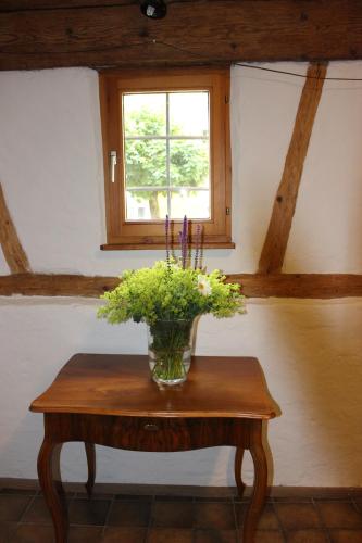 a vase of flowers on a table with a window at Espan in Isny im Allgäu