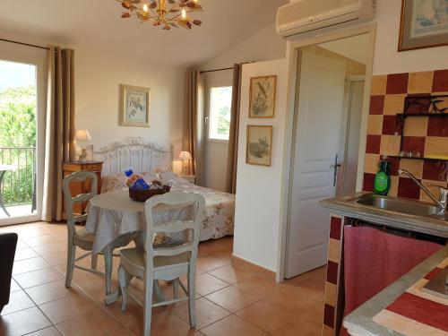 a kitchen and dining room with a table and a bed at Résidence A Merula in Calvi