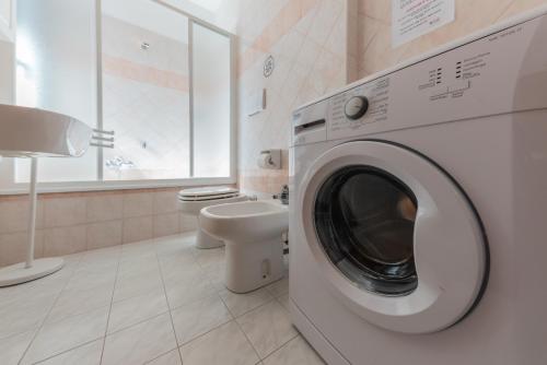 a white washing machine in a bathroom with a toilet at Residenza Nobel Appartamenti in Rimini