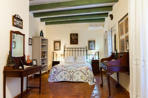 a bedroom with a bed and a desk and a bed sidx sidx sidx at La Casa del Obispo in Almagro