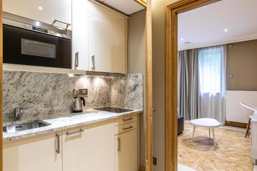 a kitchen with white cabinets and a sink at Les Jardins de St Cloud in Saint-Cloud