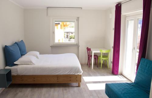 um quarto com uma cama, uma mesa e uma janela em l'Oura B&B em Challand Saint Anselme