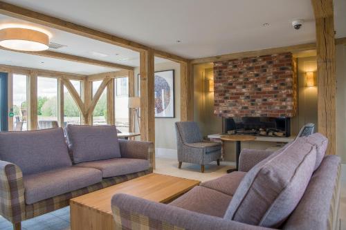 a living room with a couch and chairs and a fireplace at Sandburn Hall in York