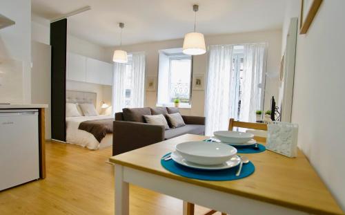 d'une cuisine et d'un salon avec une table et des assiettes. dans l'établissement D&S - Porto São Bento Apartments II, à Porto