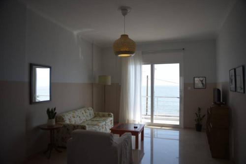 a living room with a couch and a view of the ocean at Room with a view in Kiáton