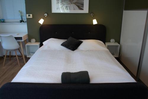 a bedroom with a large bed with white sheets and black pillows at Feels Like Home Apartments in Zagreb