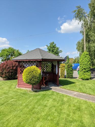 a wooden gazebo in a park with green grass at MDS Wielichowo in Wielichowo