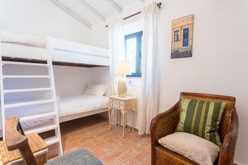 a bedroom with a bunk bed and a chair at Quinta da Alfazema in Quelfes