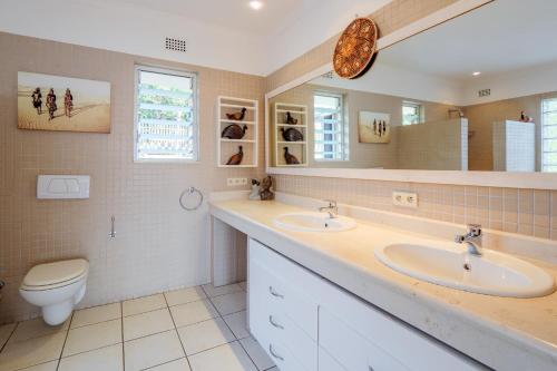 a bathroom with two sinks and a toilet at Umhlanga Beach House in Durban