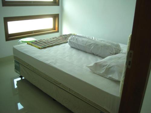 een bed met 2 kussens en een raam in een kamer bij Cemara Homestay Jogja in Yogyakarta