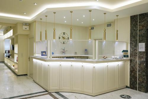 a restaurant with a counter with a clock on it at Hotel Diamantidis in Myrina