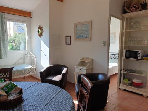 a living room with a table and chairs at Résidence A Merula in Calvi