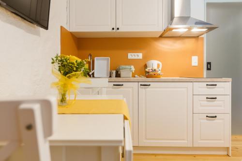 a kitchen with white cabinets and a vase of flowers at Frida's Old House in Bled