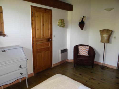 a room with a dresser and a chair and a door at Aux berges du pont du gard in Vers Pont du Gard