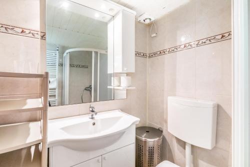 a bathroom with a sink and a toilet and a mirror at Apartmani Nadia in Punat