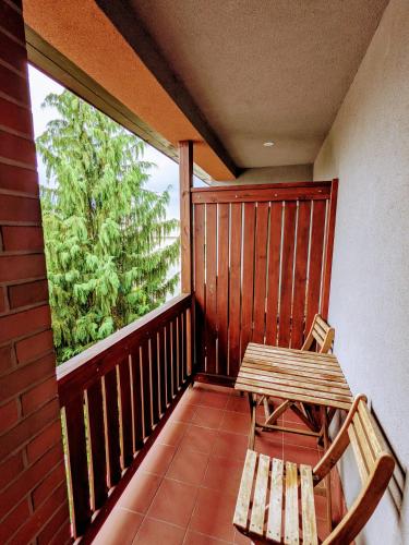 a wooden balcony with a bench and a window at MDS Wielichowo in Wielichowo