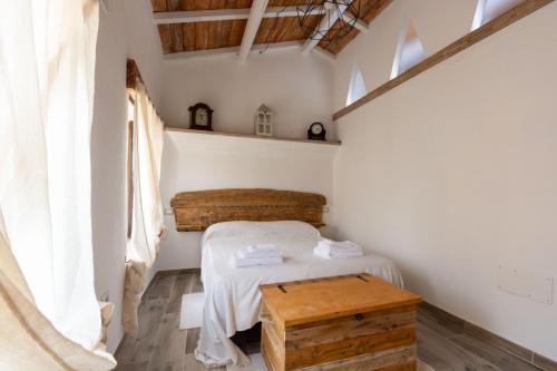 a small bedroom with a bed and a table at Villa Jumpadu in Oliena