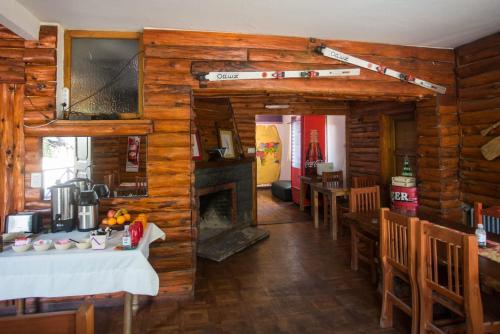 a kitchen and dining room in a log cabin at KM SUN HOSTEL in San Carlos de Bariloche