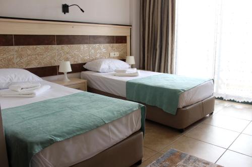Cette chambre comprend 2 lits et une fenêtre. dans l'établissement Avlu Hotel, à Kemer