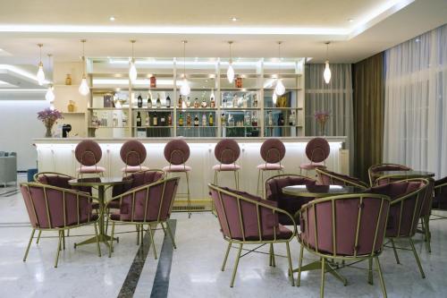 a restaurant with chairs and tables and a bar at Hotel Diamantidis in Mirina