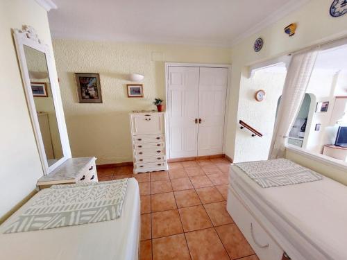 a bedroom with two beds and a mirror at FIRST LINE Villa Floor Studio Apartment with amazing sea view Air Conditioned just 50m from the beach in Adeje