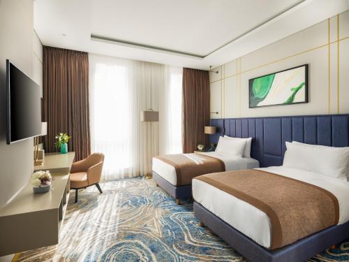 a hotel room with two beds and a desk at InterContinental Baku by IHG in Baku