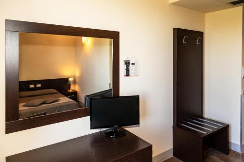 a bedroom with a mirror and a tv on a desk at Villa Montarioso in Siena