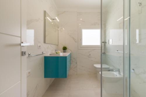 ein Badezimmer mit einem blauen Waschbecken und einem WC in der Unterkunft Residence Meridian Unità 1 in Villa San Pietro