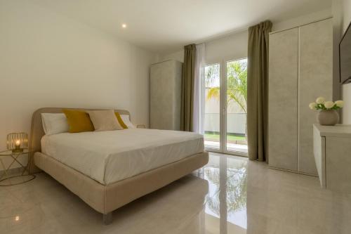 ein Schlafzimmer mit einem Bett und einem großen Fenster in der Unterkunft Residence Meridian Unità 1 in Villa San Pietro