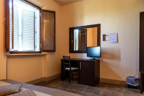 a room with a desk with a television and a mirror at Villa Montarioso in Siena
