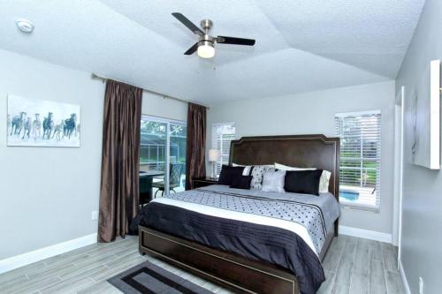 a bedroom with a bed and a ceiling fan at Splendid Newly Renovated Pool Villa on Golf Course in Haines City