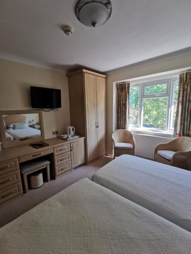 a hotel room with a bed and a television at The Grove Hotel in Bournemouth