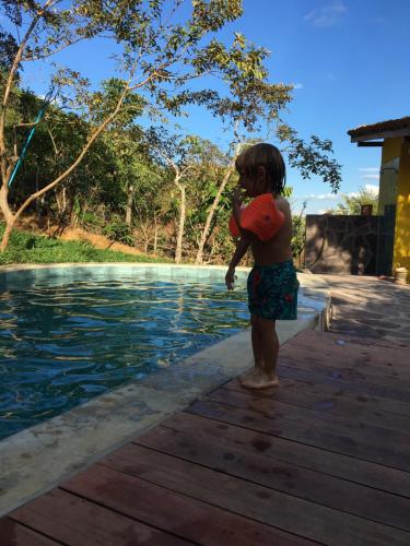 a little girl standing next to a swimming pool at Indano Art Lodge in Lamas
