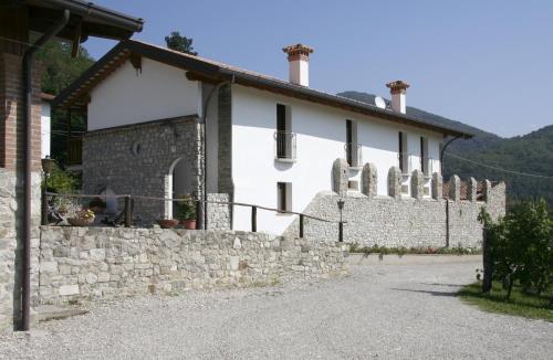 a white house with a stone wall and a building at Borgo di Corte - alloggio agrituristico in Prestento