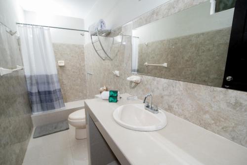 ein Badezimmer mit einem Waschbecken, einem WC und einem Spiegel in der Unterkunft Hotel Casa Real Piura in Piura