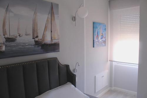 a bedroom with a bed and a picture of boats at Las Floridas Apartment in Alghero