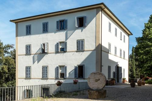 a large white building with black shutters at Villa Montarioso in Siena