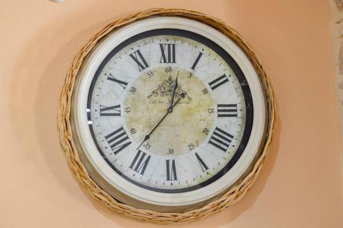 a clock is hanging on a wall at Appartamento vista incantevole Domm'e Orrosaria in Baunei