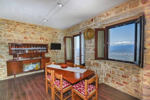 a dining room with a table and chairs and a window at Appartamento vista incantevole Domm'e Orrosaria in Baunei