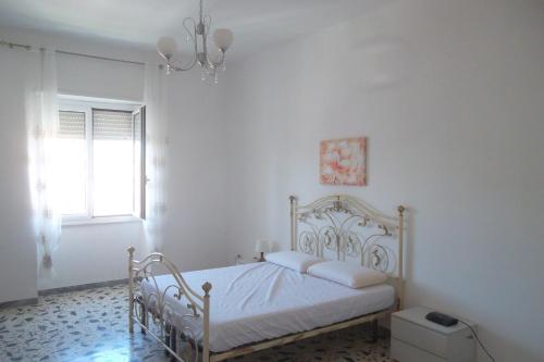 a white bedroom with a bed and a chandelier at maison jolie - Agropoli da vivere- in Agropoli