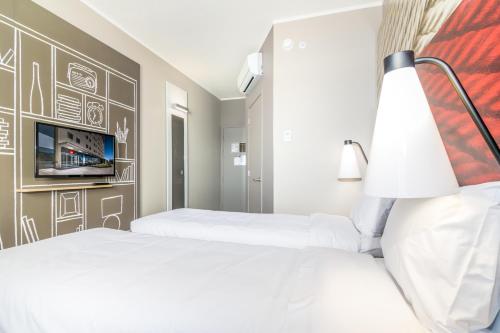 a hotel room with two beds and a tv at ibis Copiapo in Copiapó