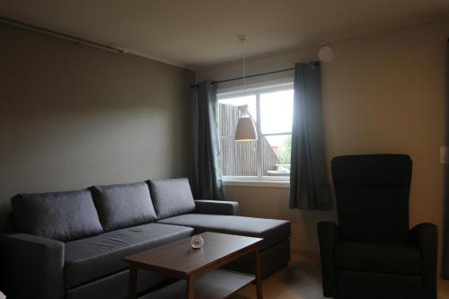 a living room with a couch and a table and a window at Setnes Feriesenter in Veblungsnes